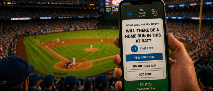 Fan holding a smartphone at a baseball stadium using FanPlay predictive gaming — real-time pick'em question asking "Will there be a home run in this at bat?" during a Dodgers vs Padres game